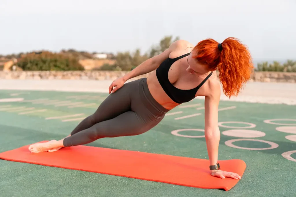 Clínica de Fitness - tonificar musculos Mujer en plancha lateral sobre colchoneta – ejercicios para abdomen