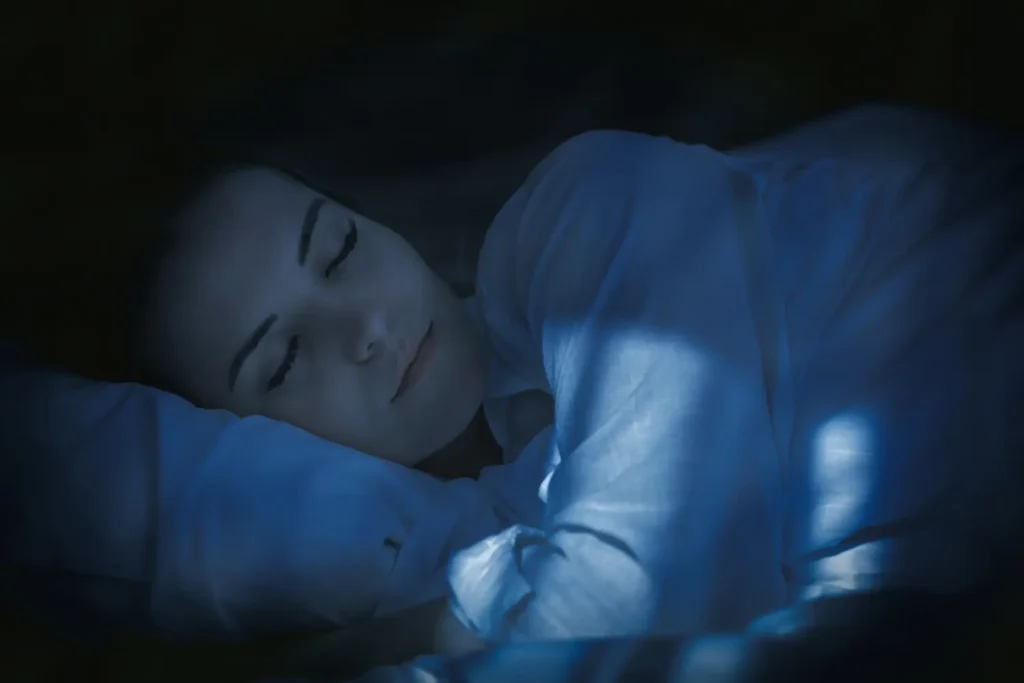 Persona durmiendo plácidamente con luz tenue – dormir las horas suficientes-clinica de fitness