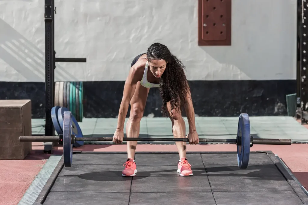 Mujer realizando peso muerto para definir musculatura- clinica de fitness
